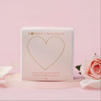 Honest Chocolat chocolate heart packaging on a pink background with roses.